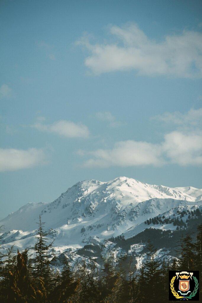 A picturesque snow-capped mountain range captured under a clear blue sky, epitomizing winter's beauty.