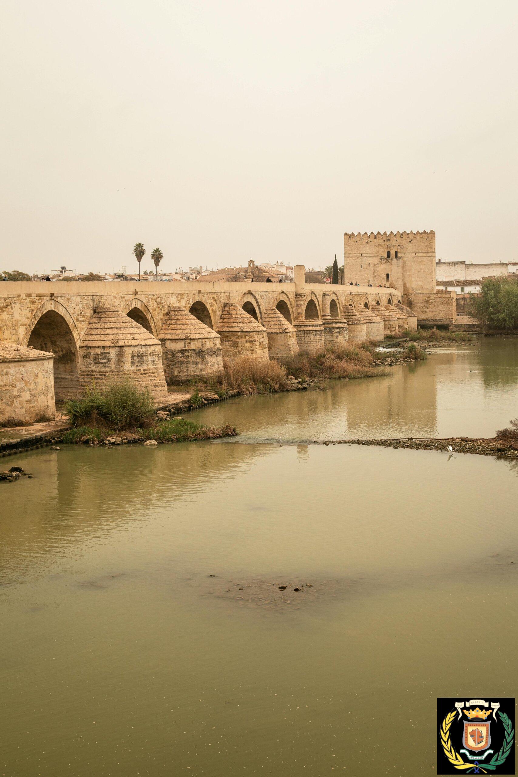 Historic Roman bridge spanning the Guadalquivir River in Córdoba, Spain, showcasing ancient architecture.