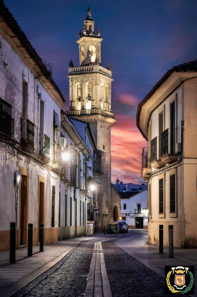 Capture of the illuminated bell tower on a cobblestone street in Córdoba during twilight.