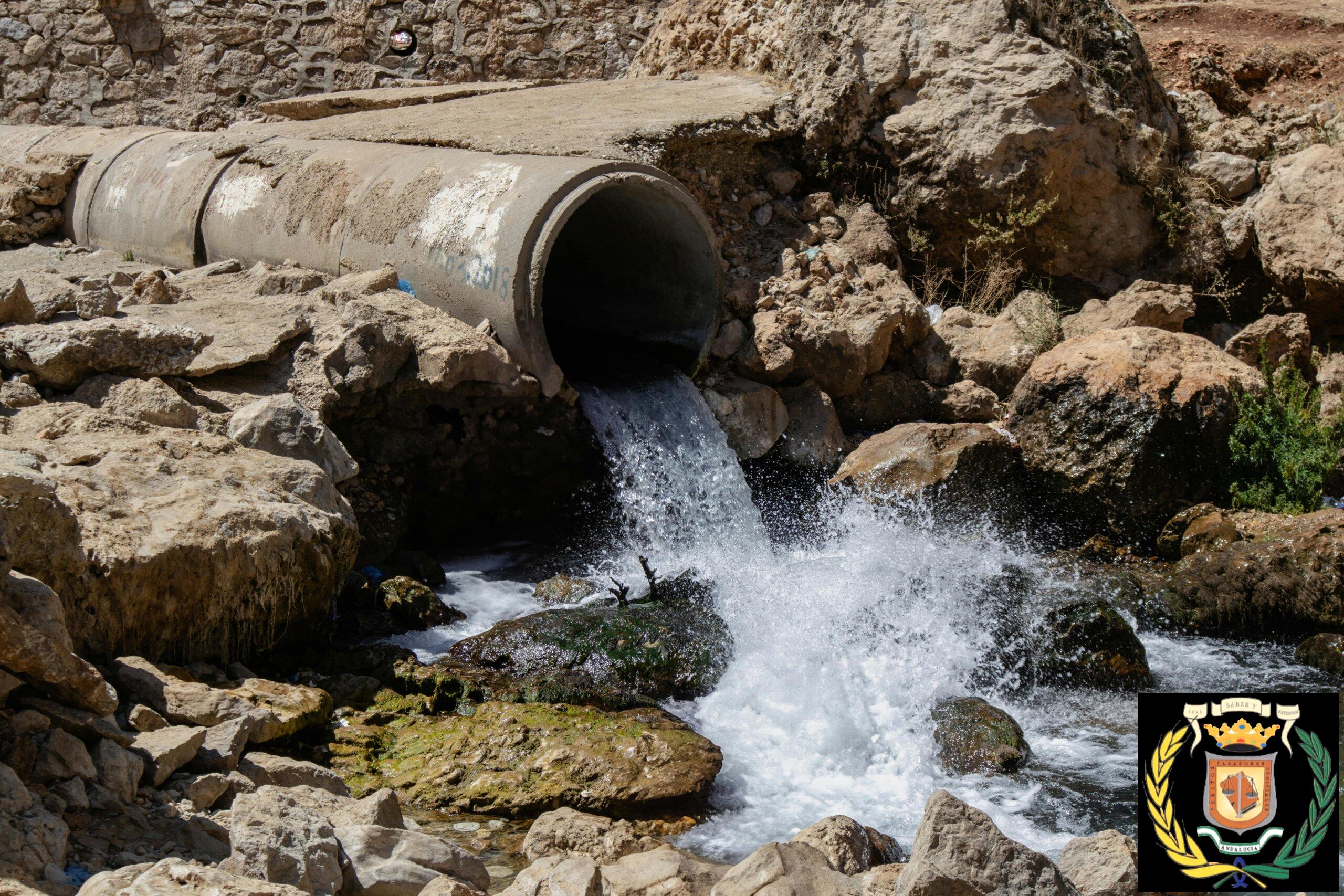 Vibrant water flow through a large pipe in the rocky landscape of Sinek, Diyarbakır.