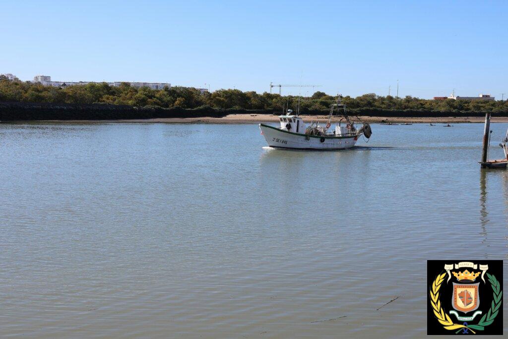 A serene view of a fishing boat on the Guadalete River in El Puerto de Santa María, Spain.