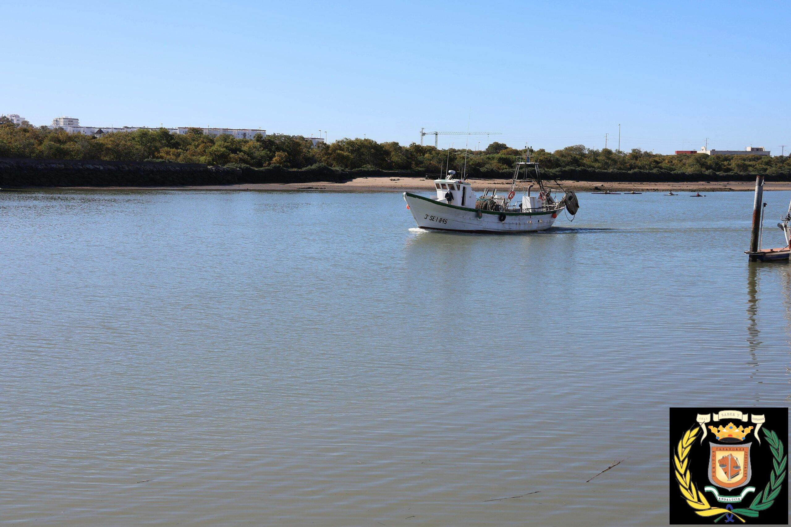 A serene view of a fishing boat on the Guadalete River in El Puerto de Santa María, Spain.